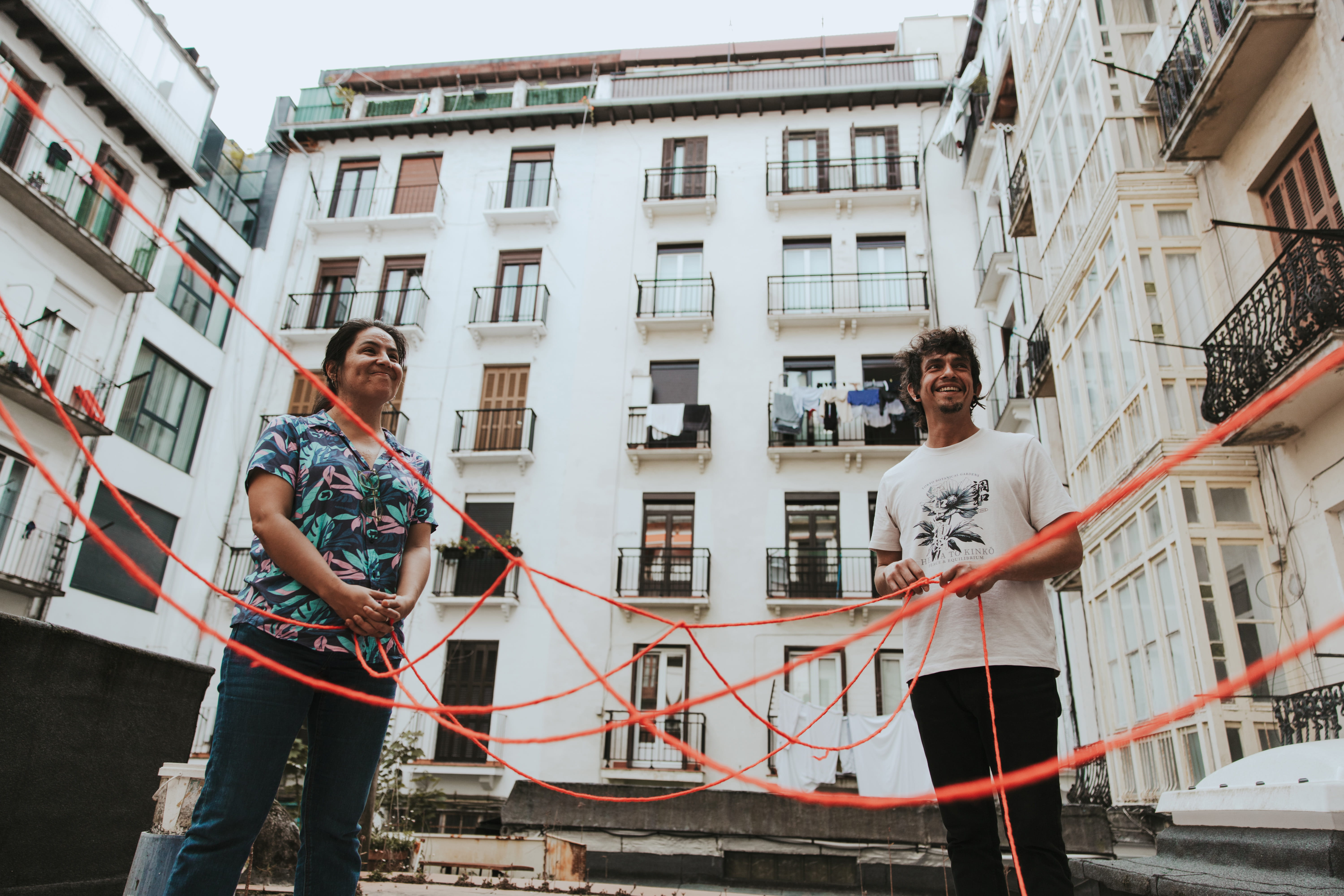 Tres personas abrazandose en una plaza durante una actividad comunitaria